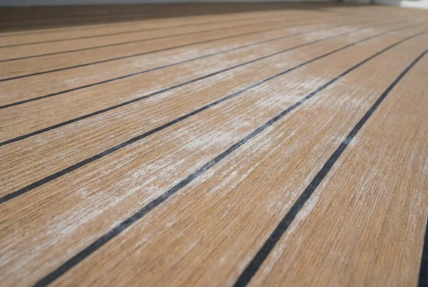 Kunststof teakdek met witte aanslag door kalk of zeepresten